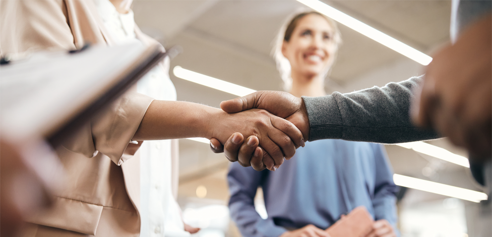 Close-up of business partners handshaking after successful agreement in office.